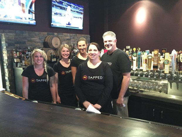 Tapped crew Caitlin Zakutney, Jenna Martin, Alyssa Liebdzinski, Bridget Noel, and Mike Kirk in front of the bar